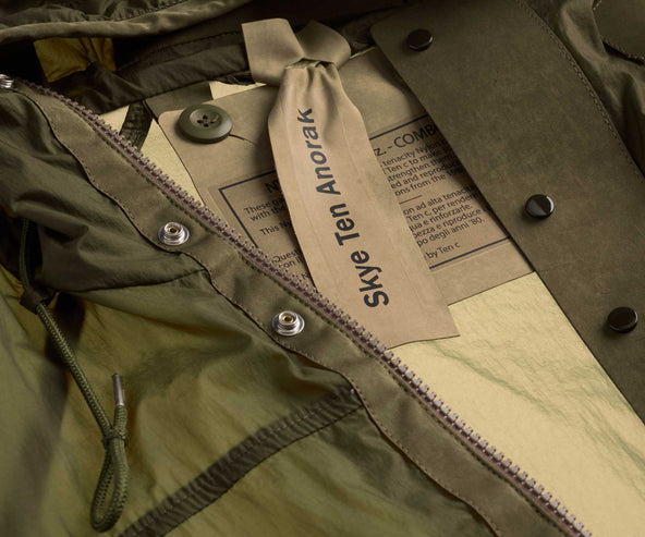 Close-up of a green jacket with a brand label on a beige background