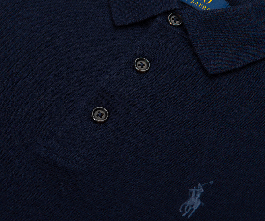 Navy blue polo shirt with brand logo on a dark background