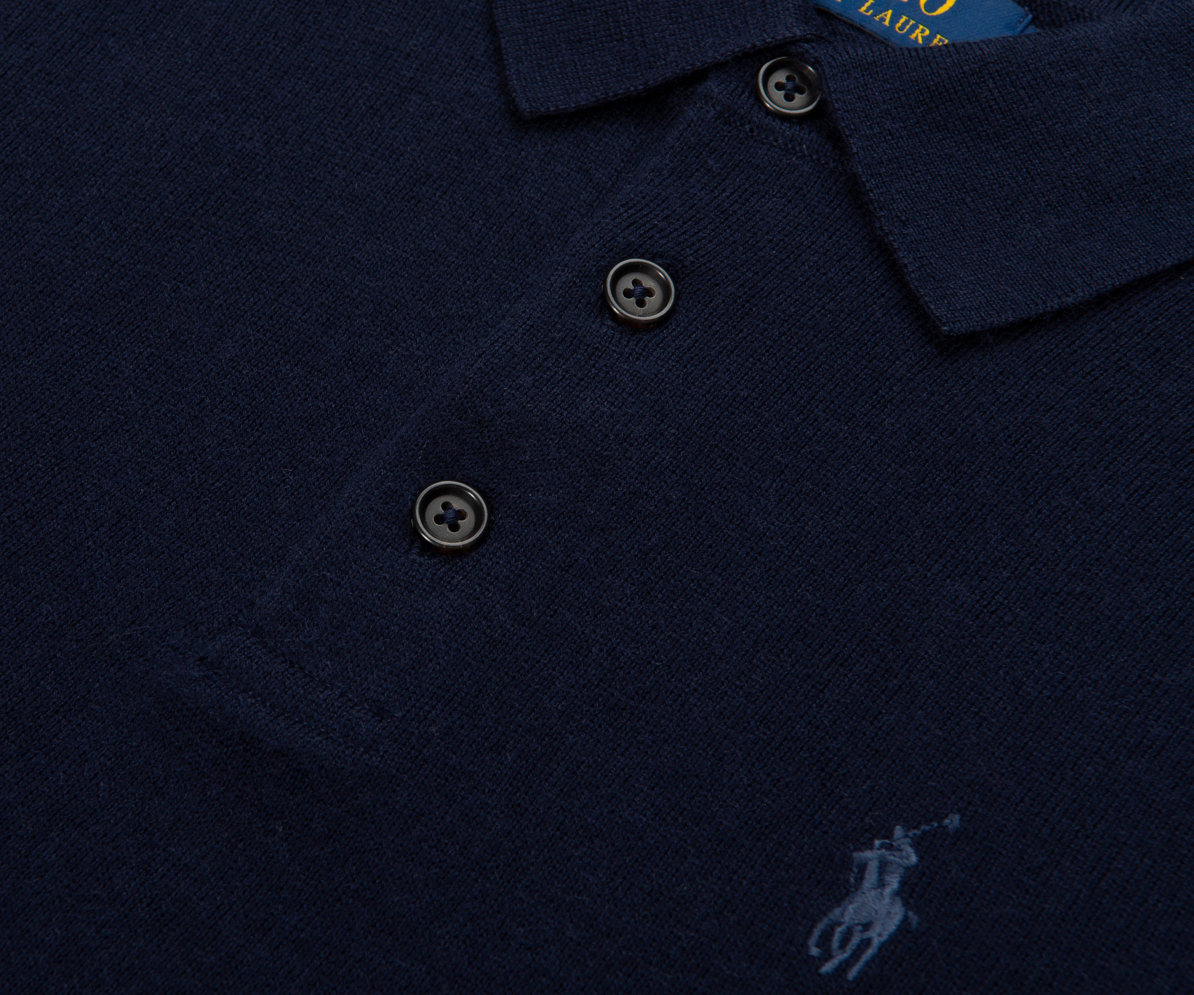 Navy blue polo shirt with brand logo on a dark background