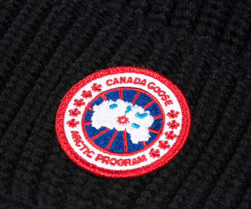 close-up of Canada Goose logo on a black beanie | Pockets