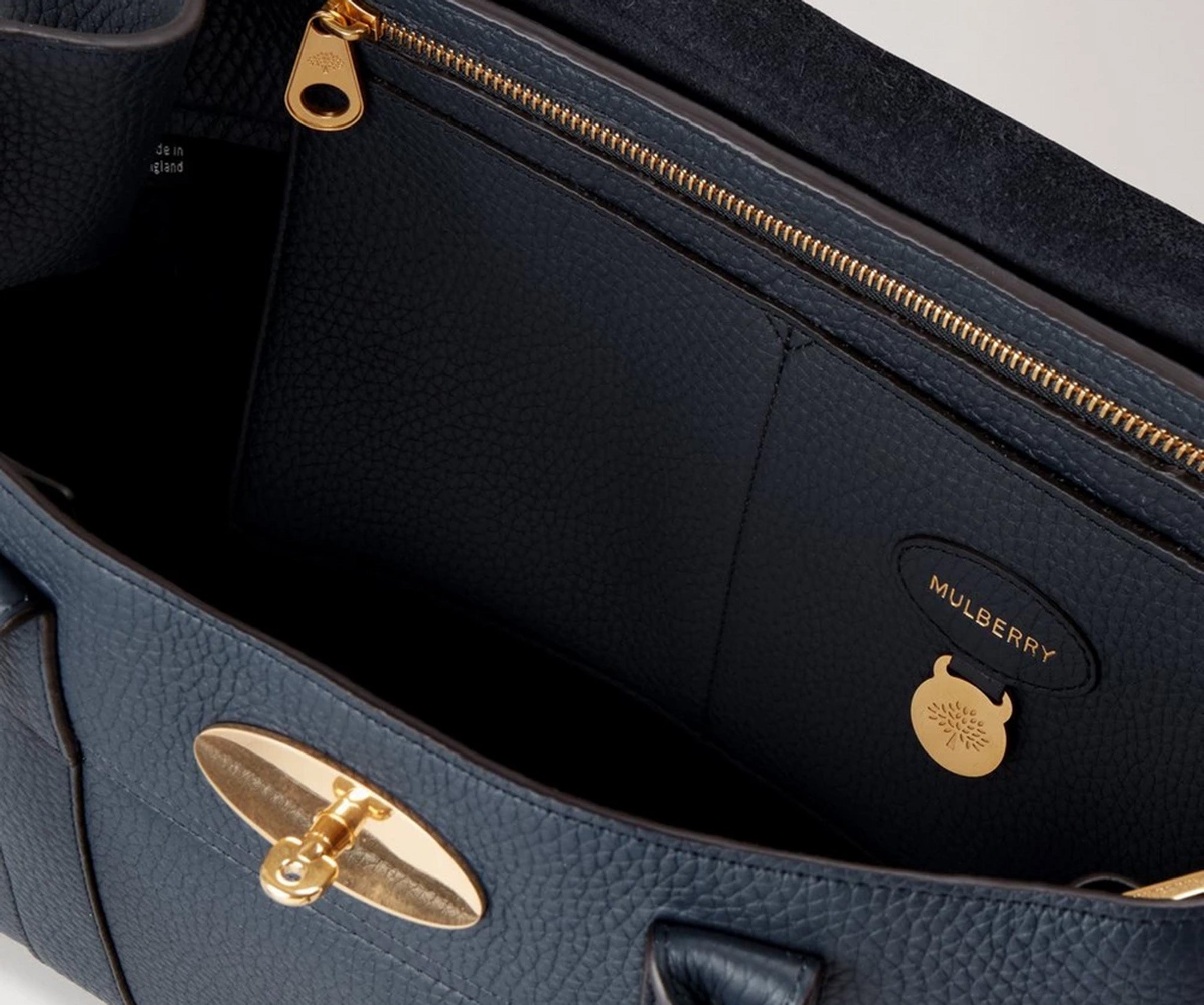 Navy leather handbag with gold hardware and Mulberry logo.