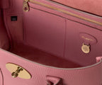 Close-up of a pink Mulberry handbag with gold hardware.