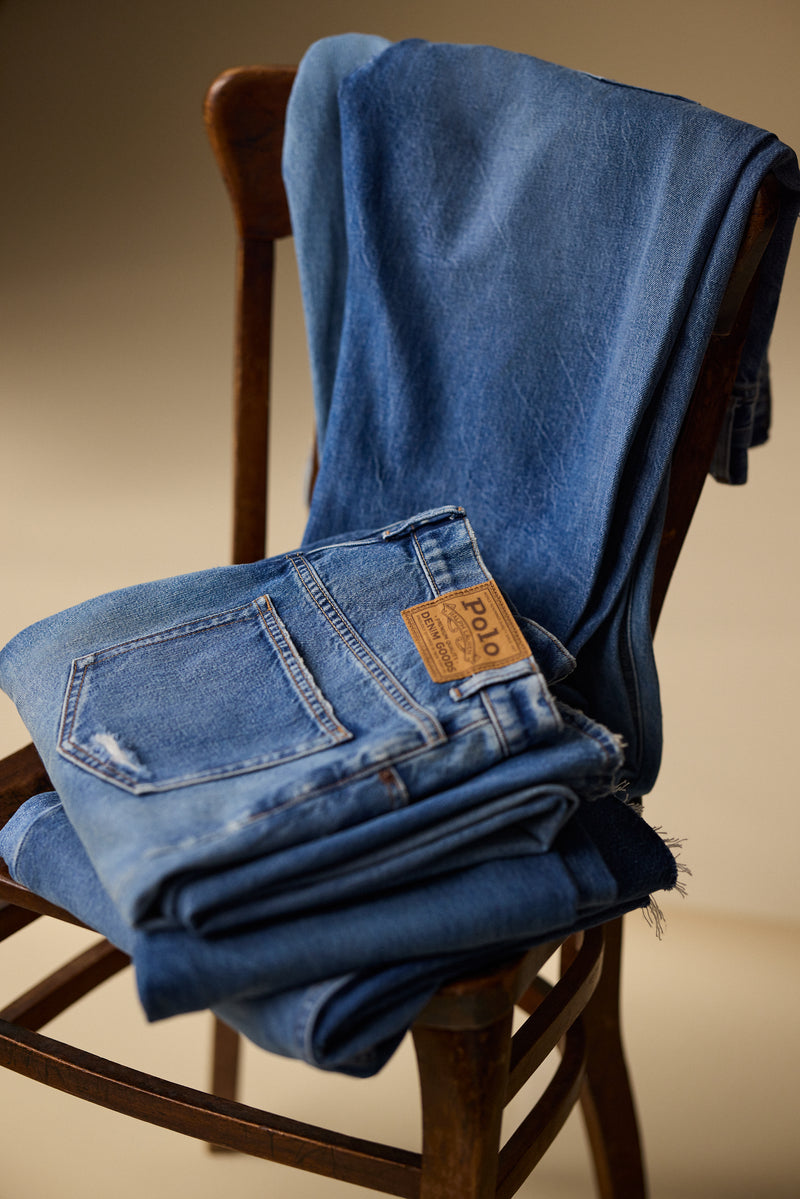 Folded blue jeans with a Polo Ralph Lauren label on a wooden chair | Pockets