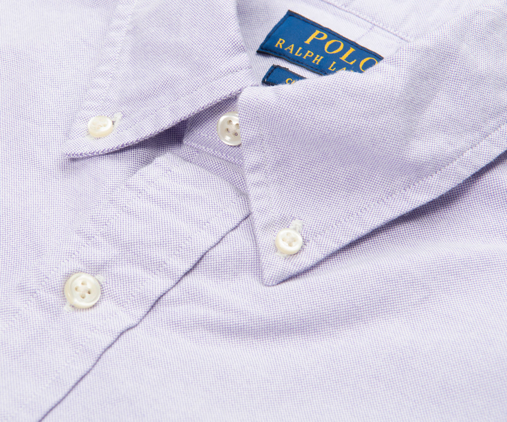 Close-up of a light purple shirt with white buttons and Polo Ralph Lauren label.
