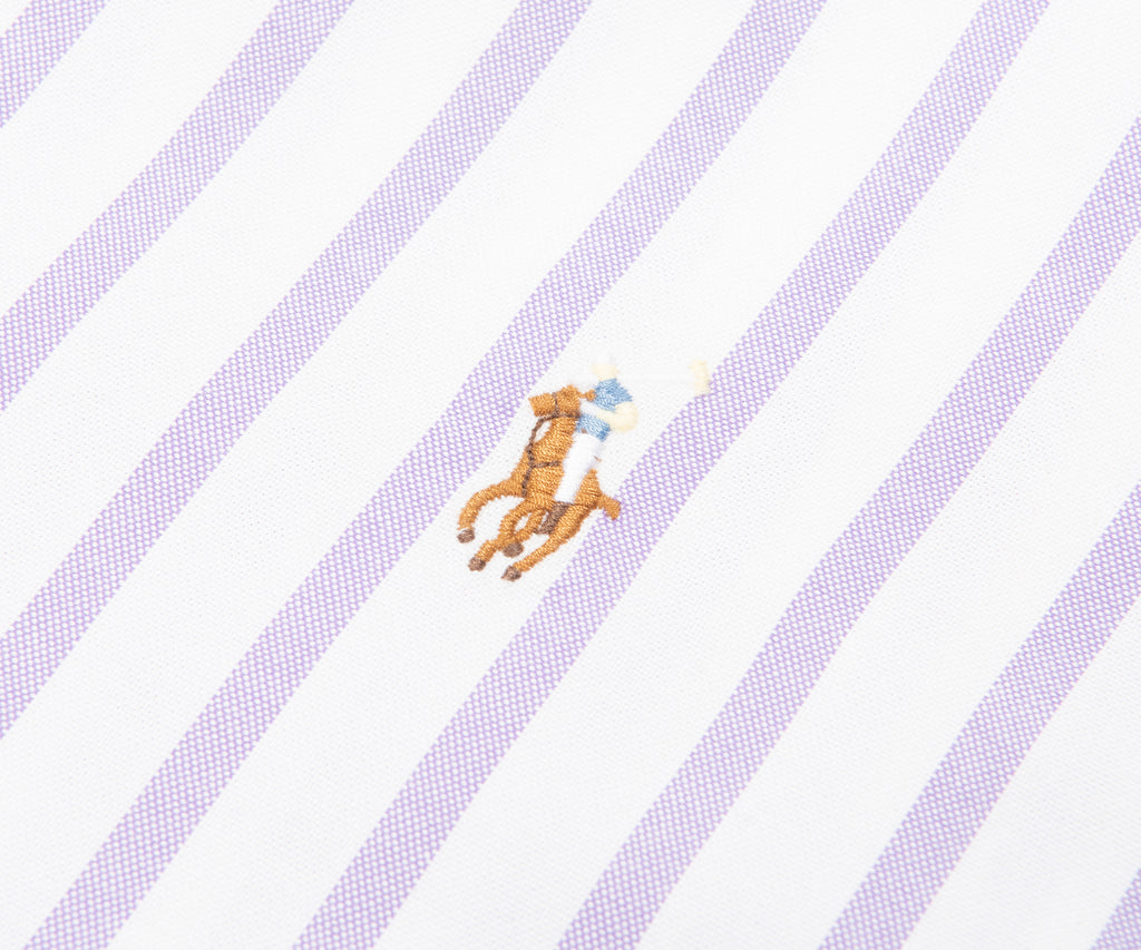 Close-up of a shirt with diagonal stripes and a small logo on a white background