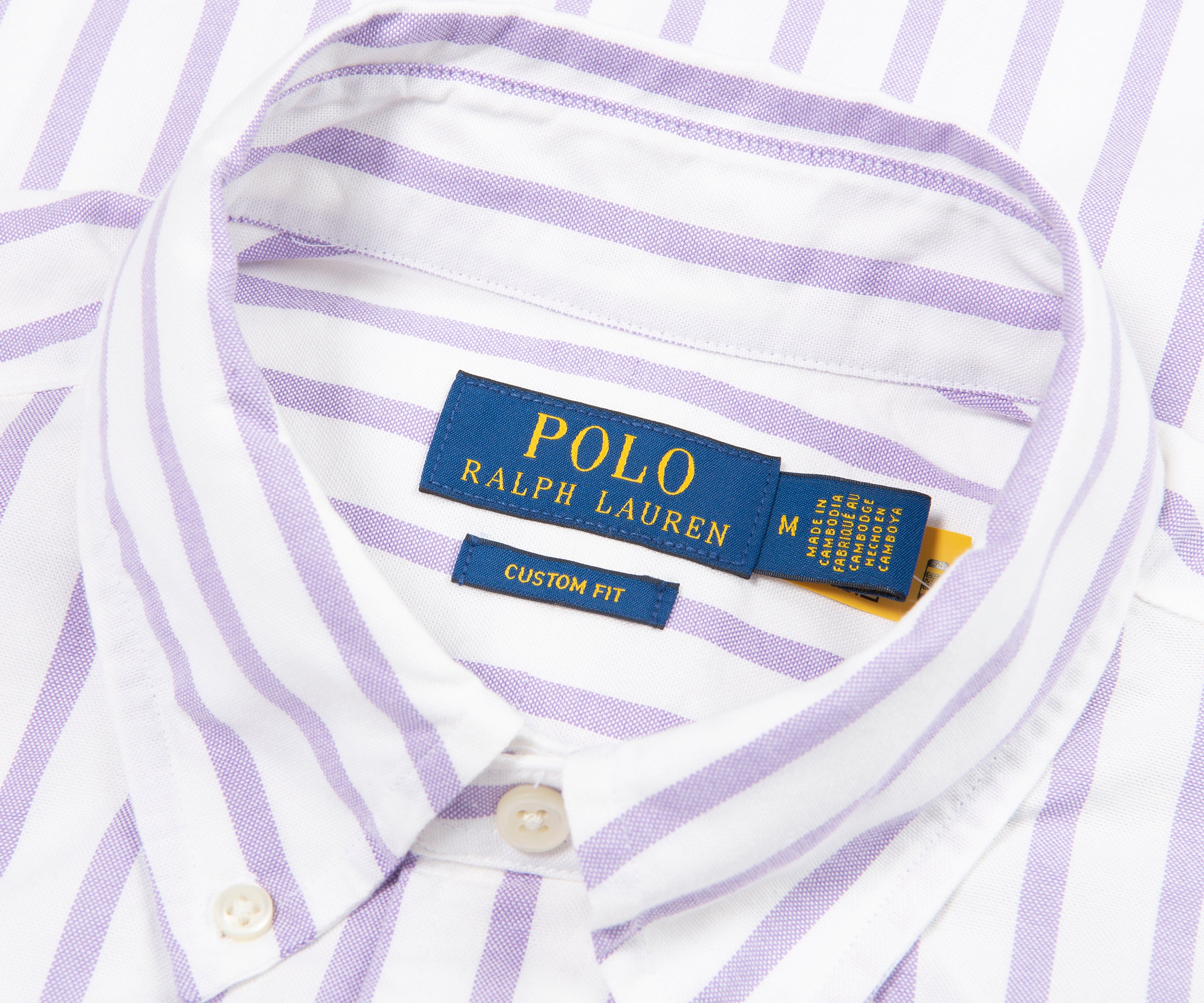 Close-up of a Polo Ralph Lauren shirt with a label on a white and purple striped background