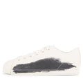 White sneaker with black paint splatter on a white background