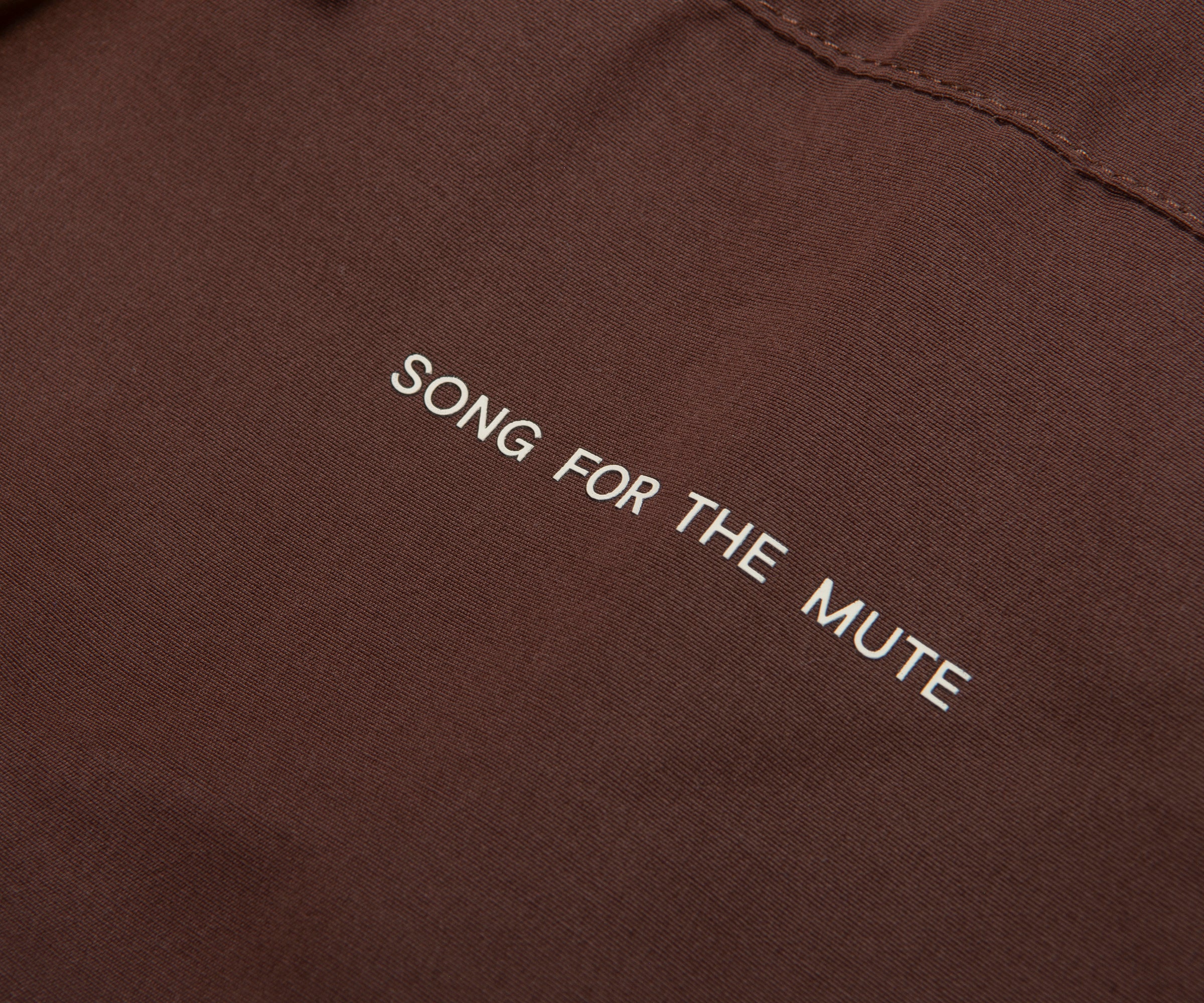 Brown fabric with 'SONG FOR THE MUTE' embroidered on it