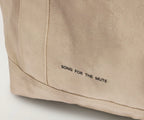 Beige fabric with 'SONG FOR THE MUTE' branding on a light gray background