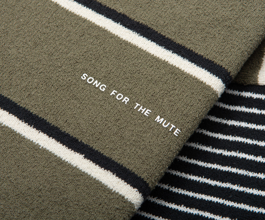 Text 'SONG FOR THE MUTE' on a striped fabric background
