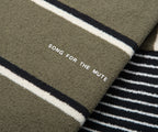 Text 'SONG FOR THE MUTE' on a striped fabric background