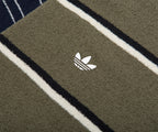Close-up of a green Adidas towel with a logo on a striped background