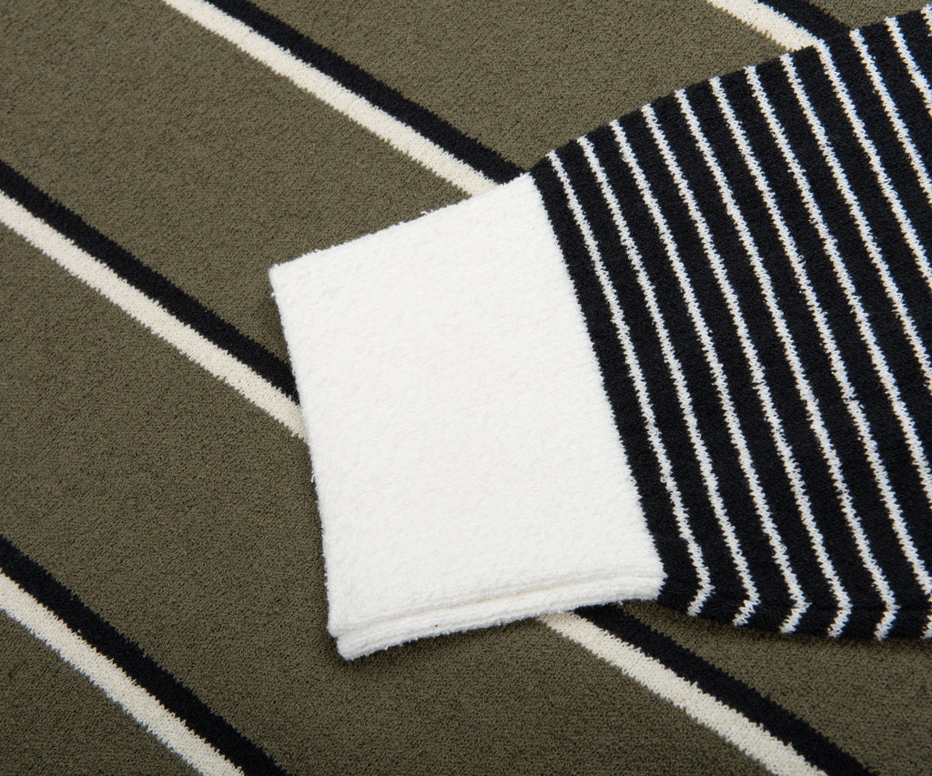 Close-up of a black and white striped sock on a striped fabric background