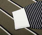 Close-up of a black and white striped sock on a striped fabric background
