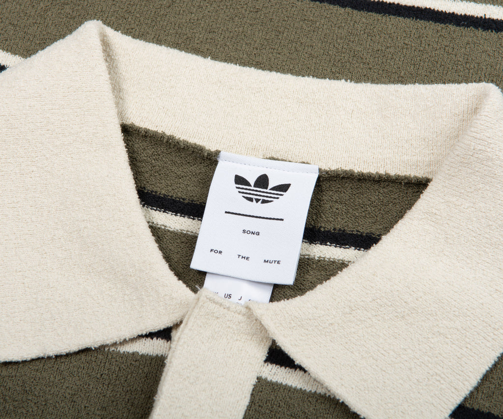 Close-up of a sweater with an Adidas label on a patterned background