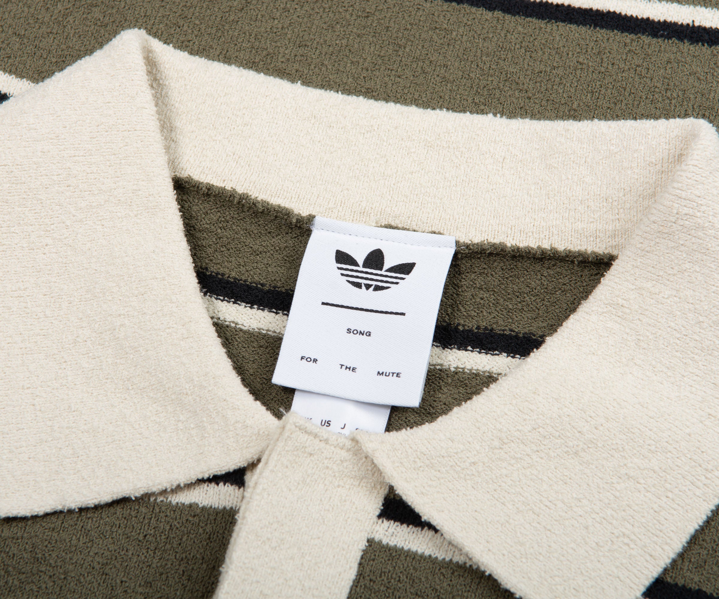 Close-up of a sweater with an Adidas label on a patterned background