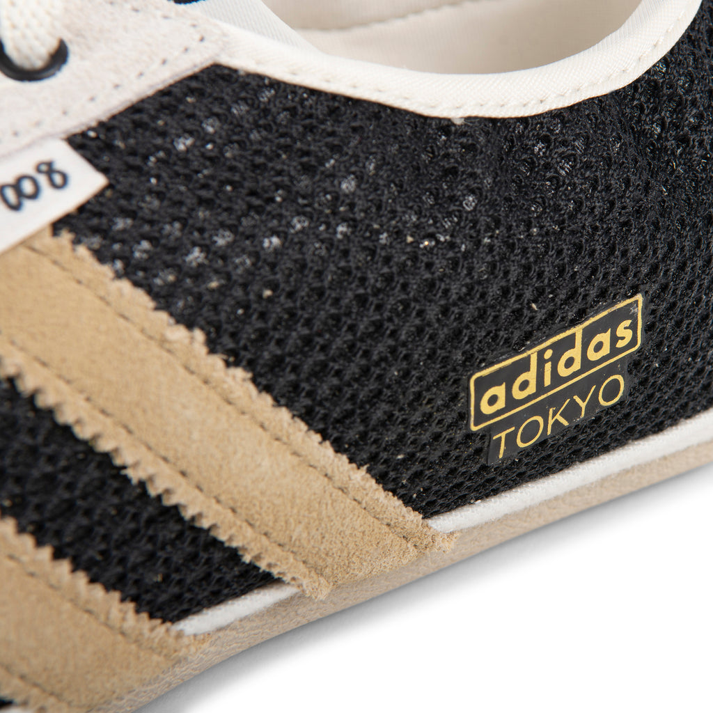 Close-up of Adidas Tokyo sneaker with black and beige details on a white background