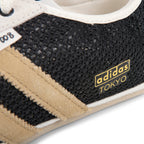 Close-up of Adidas Tokyo sneaker with black and beige details on a white background