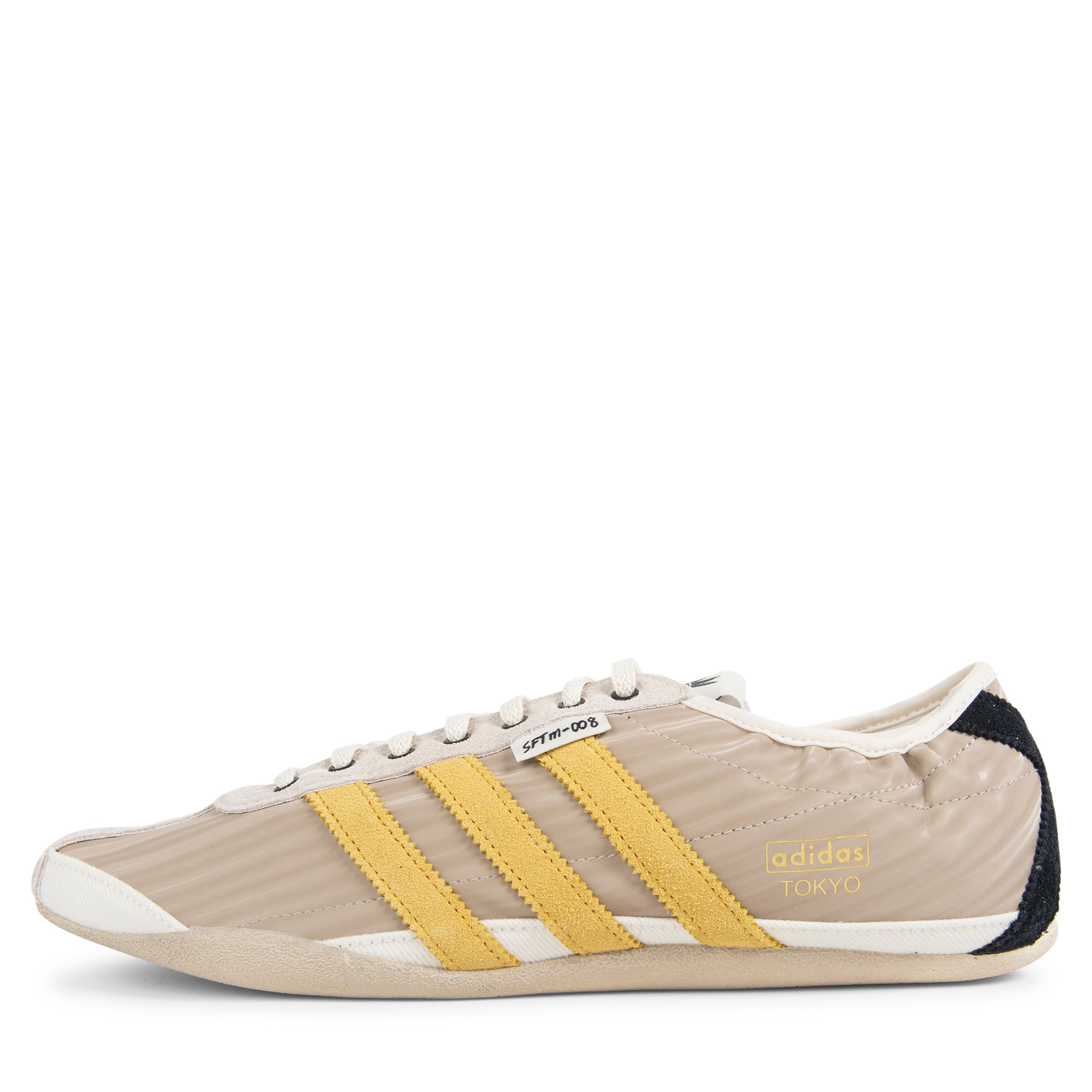 Beige Adidas sneaker with yellow stripes on a white background