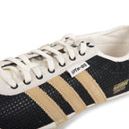 Black and beige Adidas sneaker with white laces on a white background
