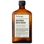 A brown bottle of Aesop mouthwash with a white label displaying the product name and key ingredients.