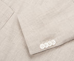Close-up of a light gray suit with white buttons on a matching fabric background