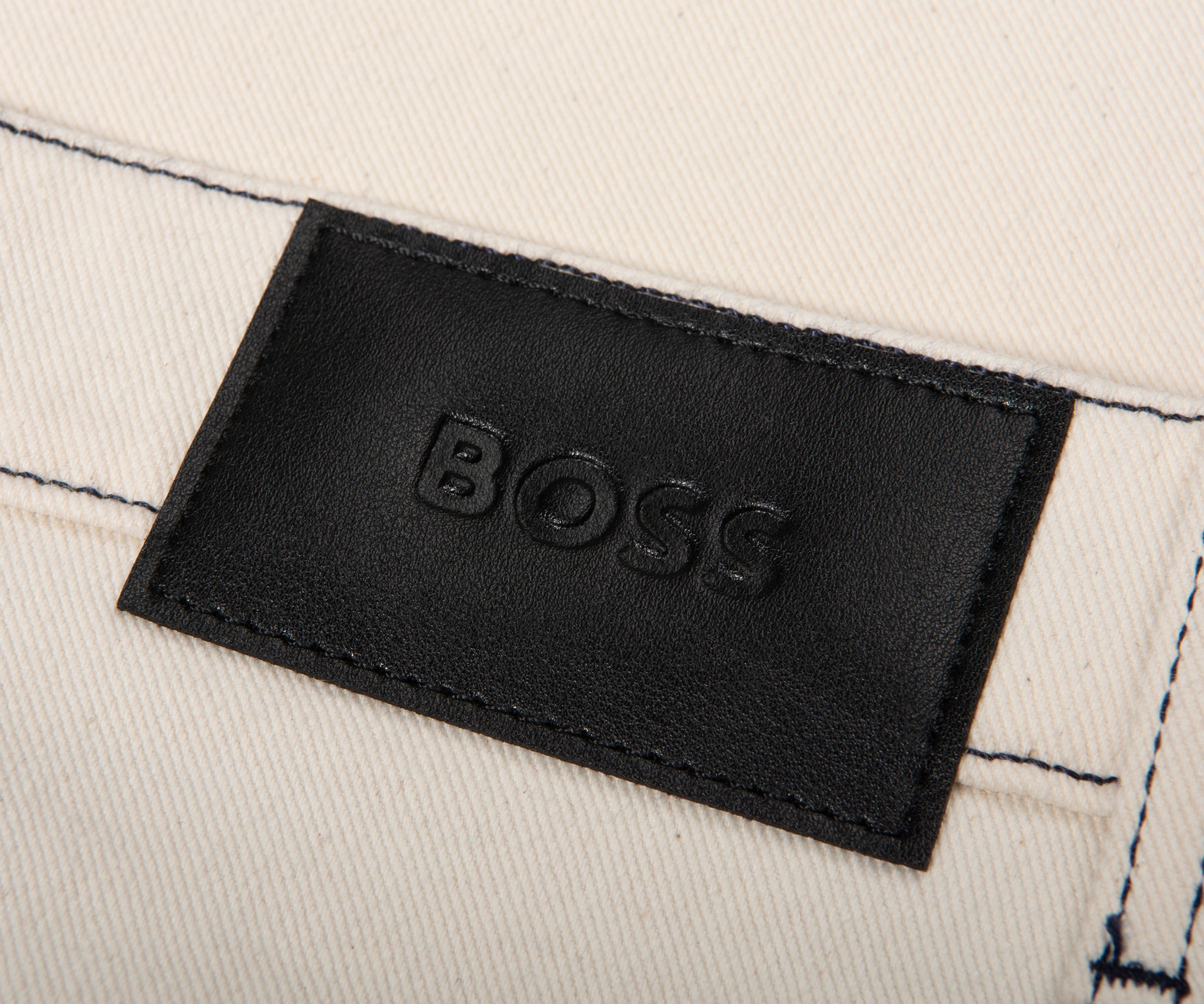 Close-up of a black 'BOSS' label on beige fabric.