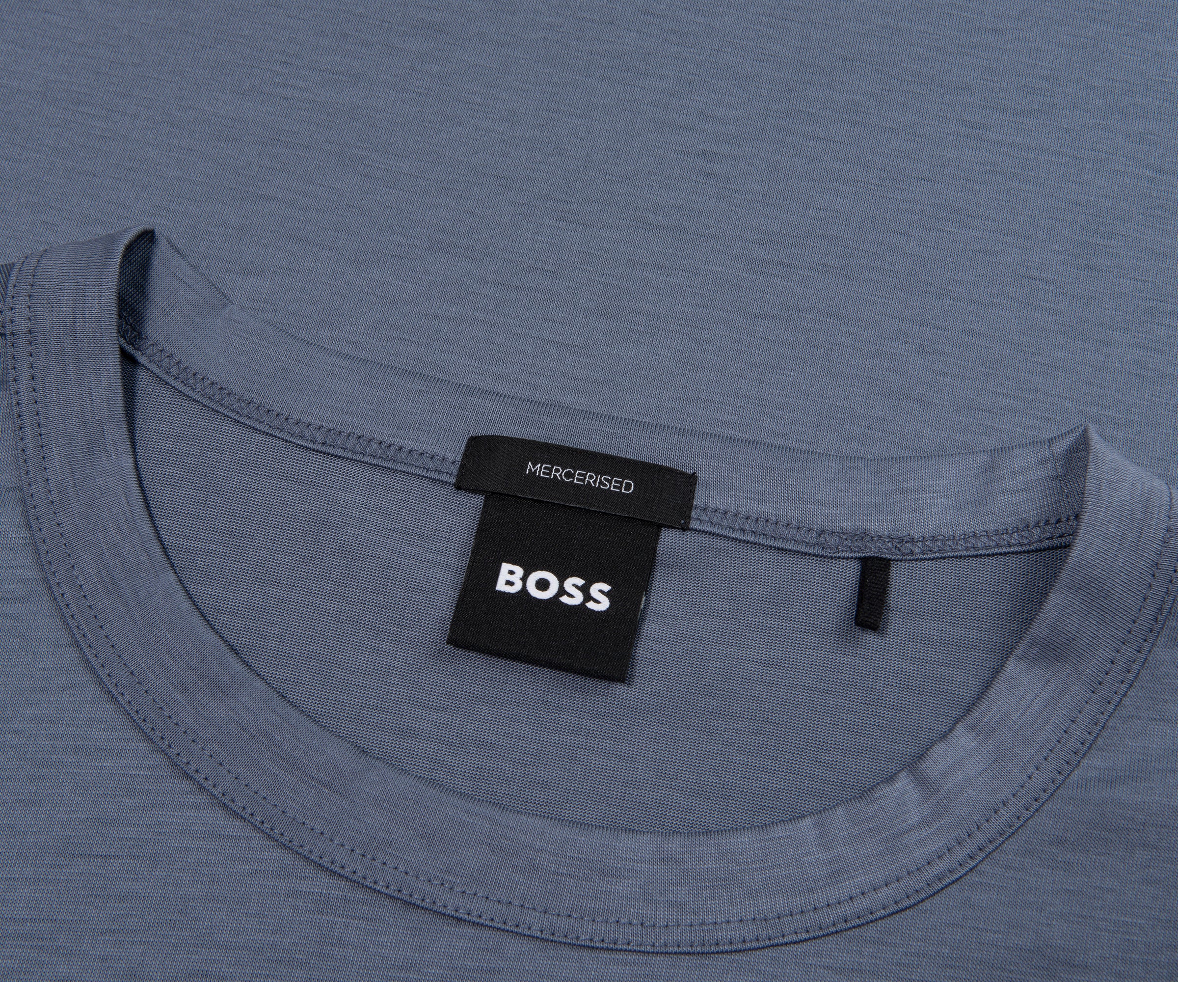Close-up of a blue shirt with a BOSS label on a gray background