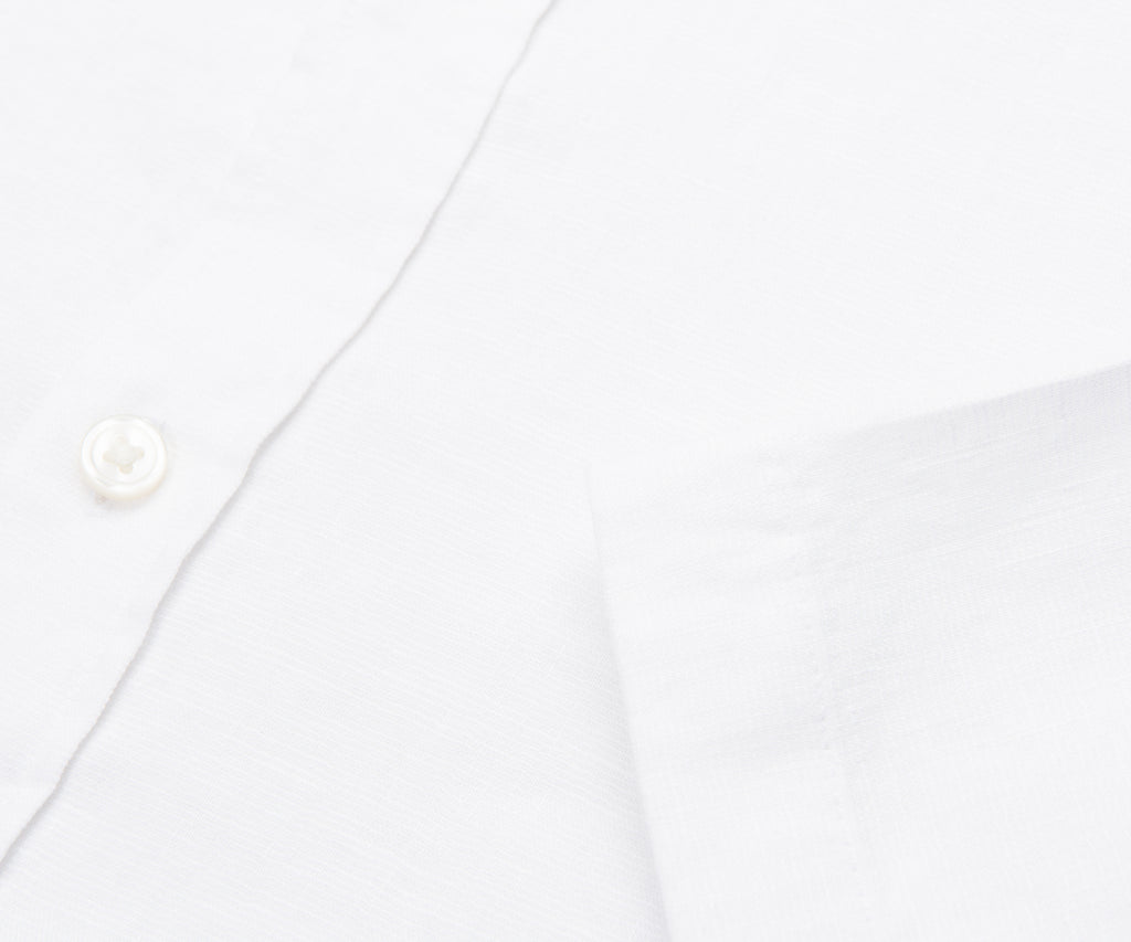 Close-up of a white shirt with a button on a white background