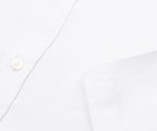 Close-up of a white shirt with a button on a white background