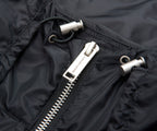 Close-up of a black jacket zipper with a brand logo.