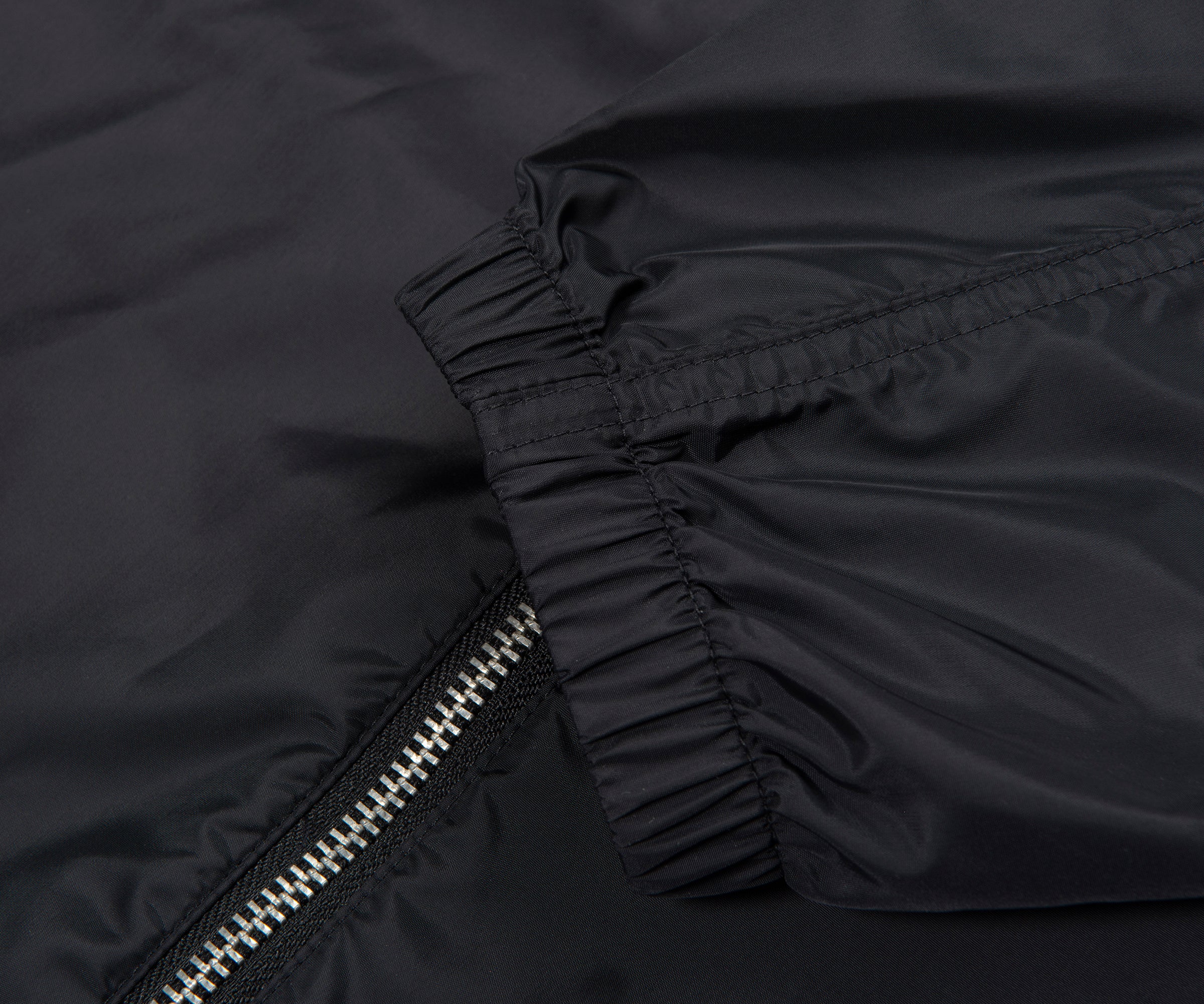 Close-up of a black jacket with a zipper on a dark background