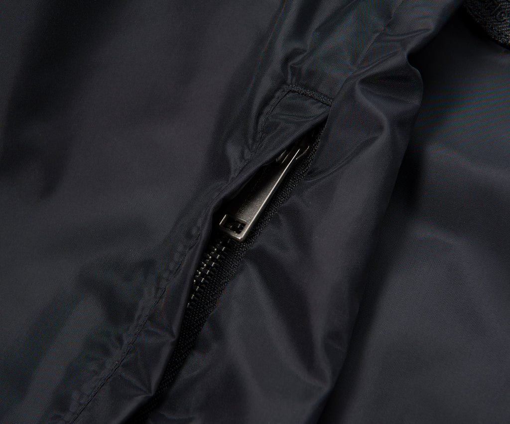 Close-up of a zipper on a dark fabric surface