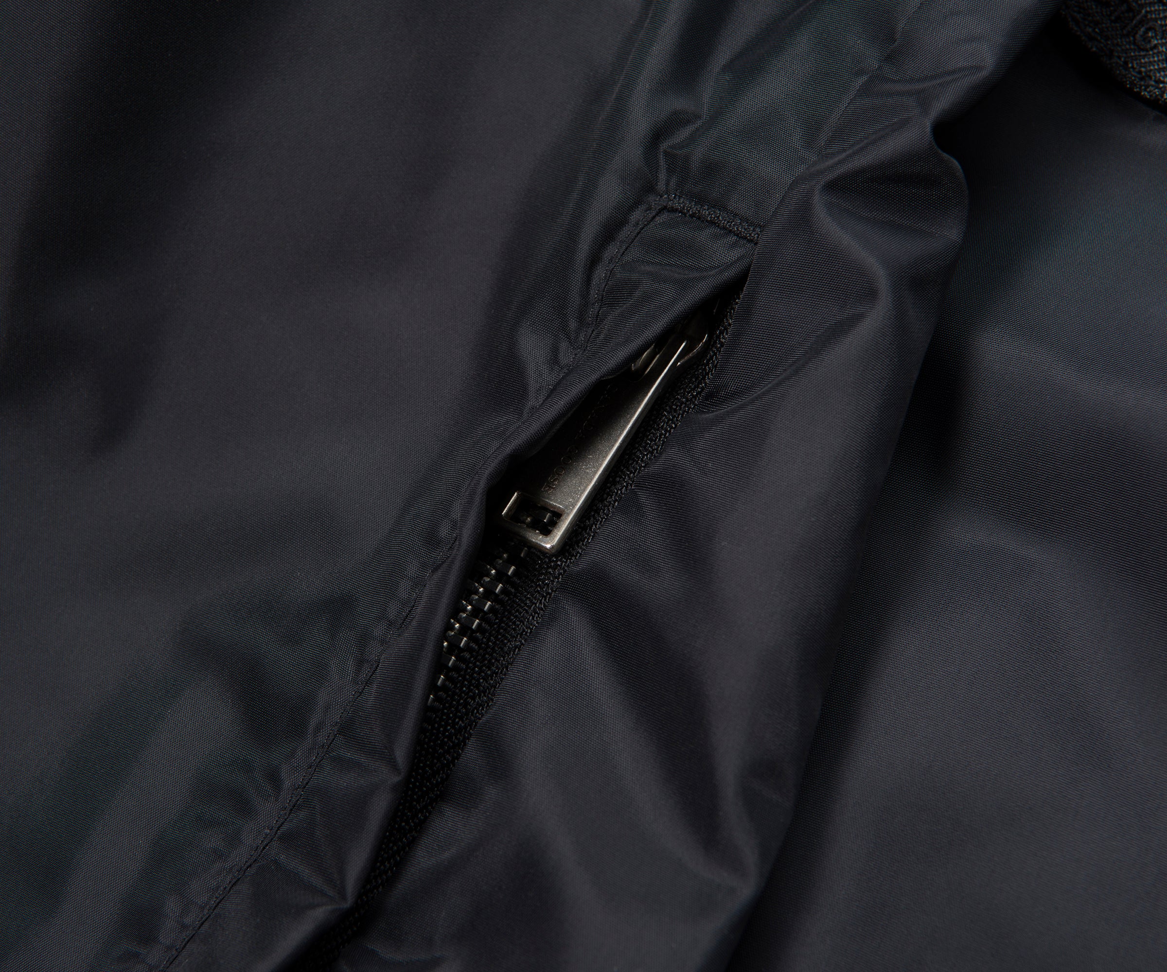 Close-up of a zipper on a dark fabric surface