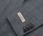 Close-up of a gray textured fabric with a Canali label and buttons.
