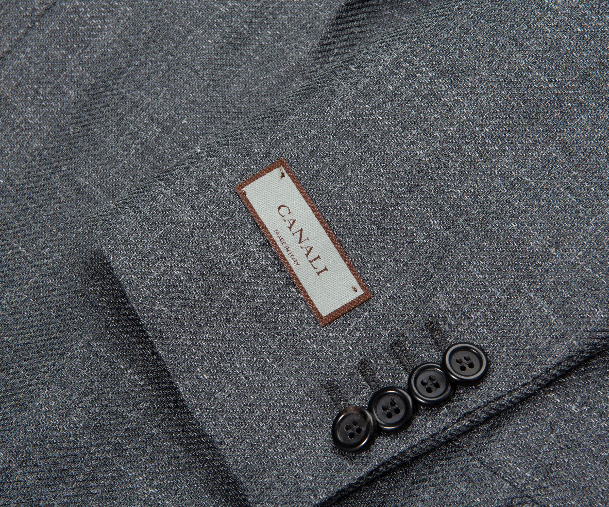 Close-up of a gray textured fabric with a Canali label and buttons.