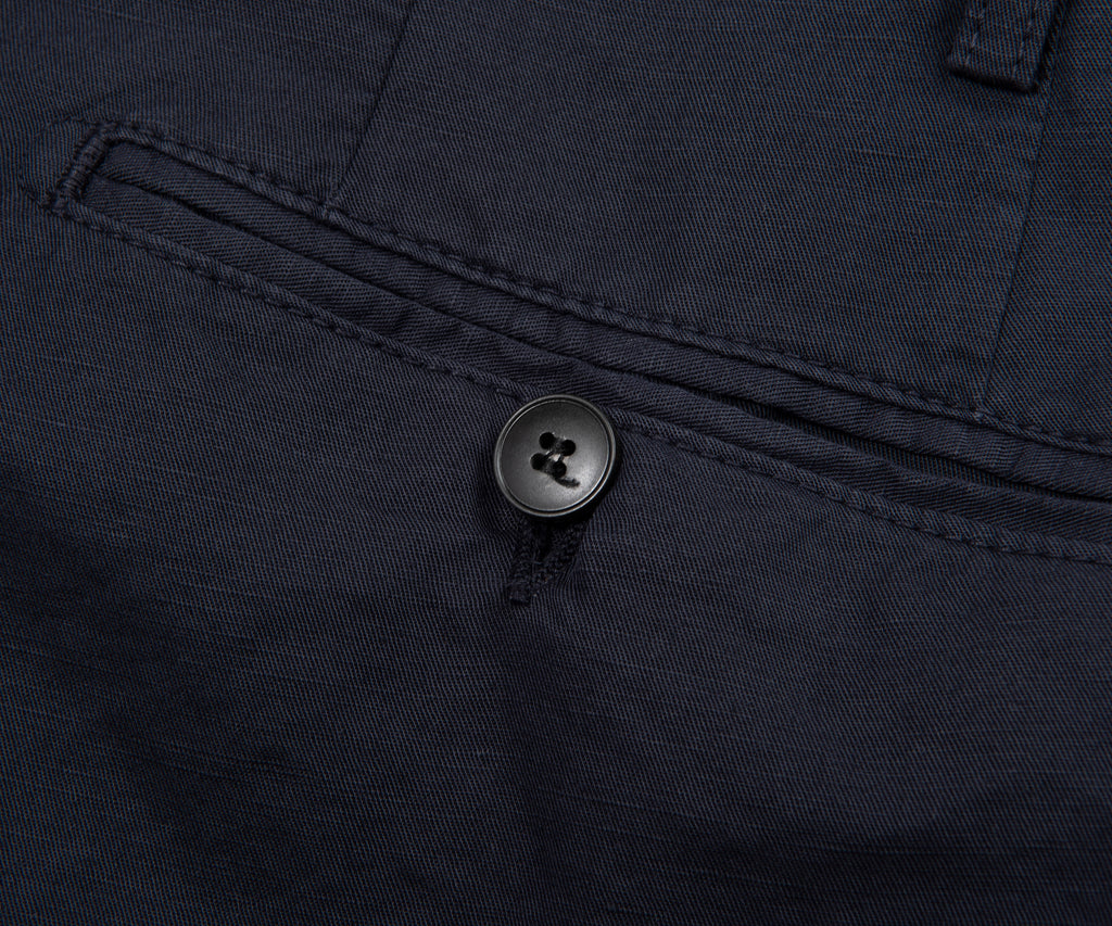 Close-up of a button on a dark fabric, likely a shirt or jacket.