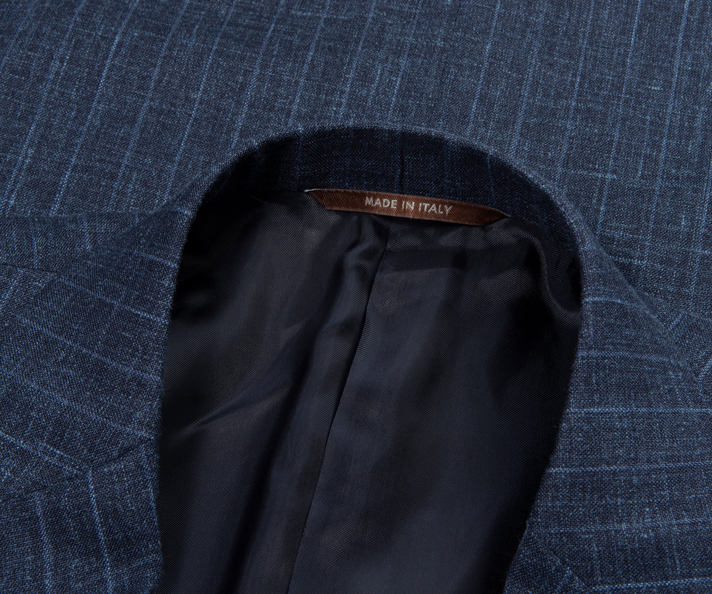 Close-up of a blue textured fabric with a 'Made in Italy' label on a matching background.