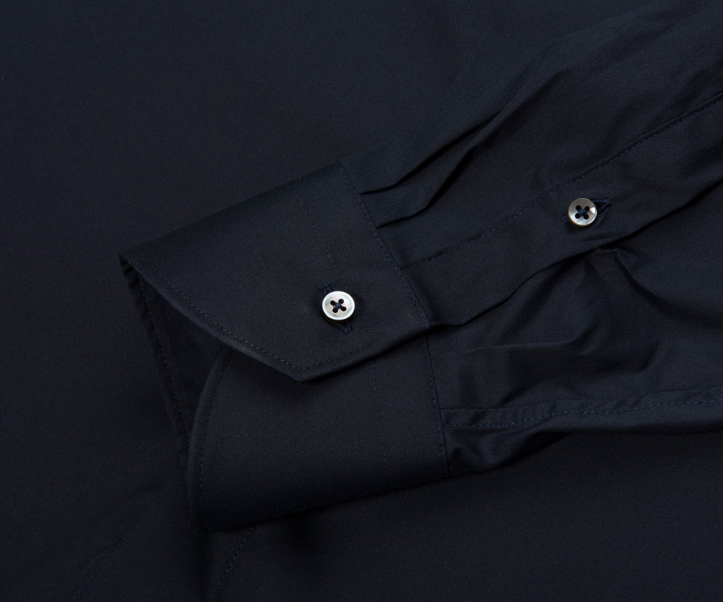 Close-up of a black shirt with button details on a dark background