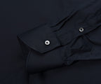 Close-up of a black shirt with button details on a dark background