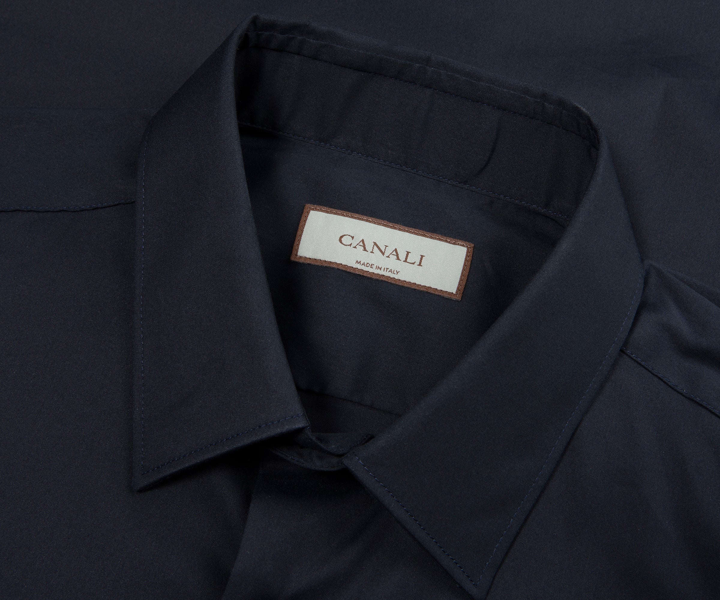 Close-up of a dark blue shirt collar with a Canali label.