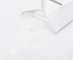 White dress shirt on a hanger against a white background