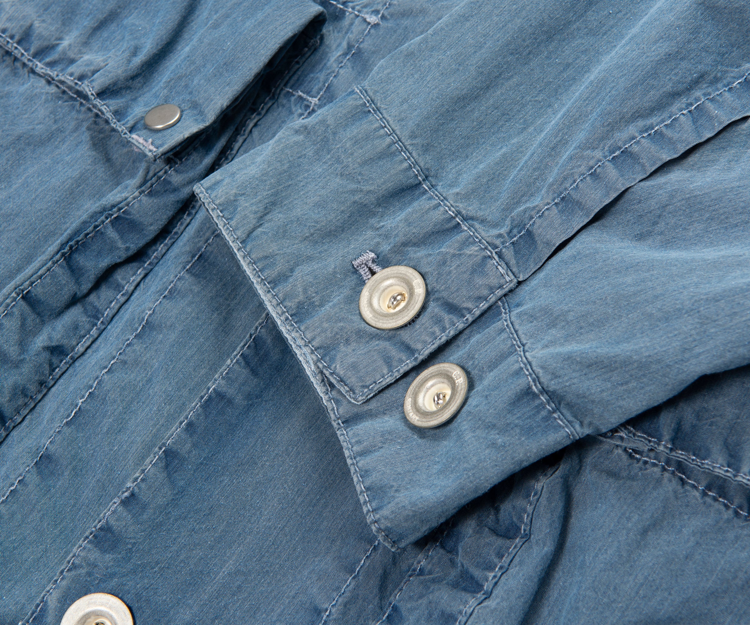 Close-up of a blue denim shirt with button details