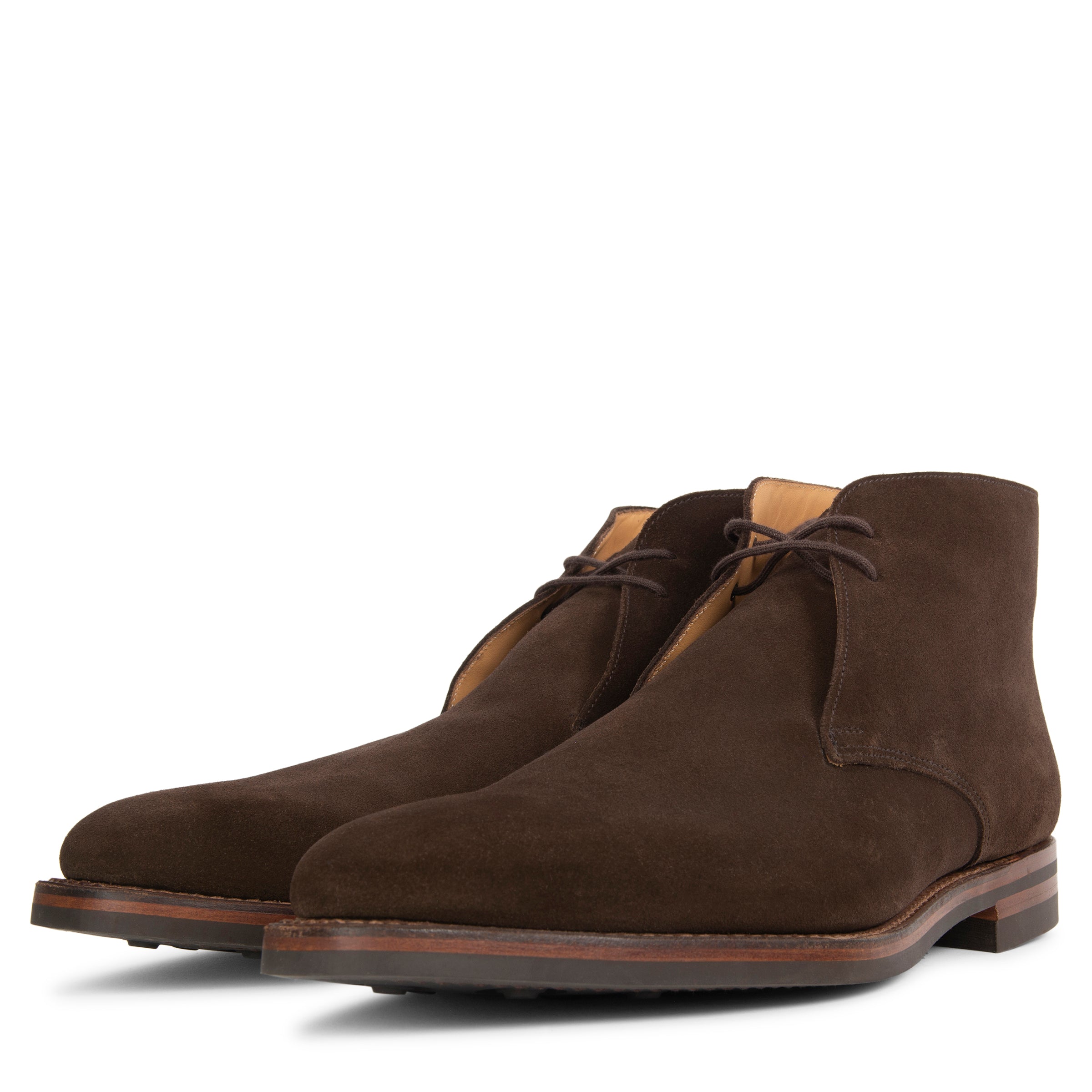 Pair of brown suede chukka boots on a white background