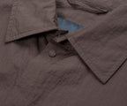 Close-up of a gray jacket with a button and blue lining.