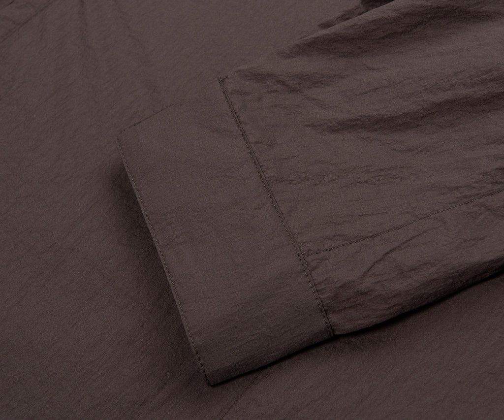 Dark brown textured fabric with a folded corner