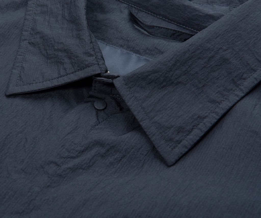 Close-up of a dark gray textured fabric with a button