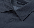 Close-up of a dark gray textured fabric with a button