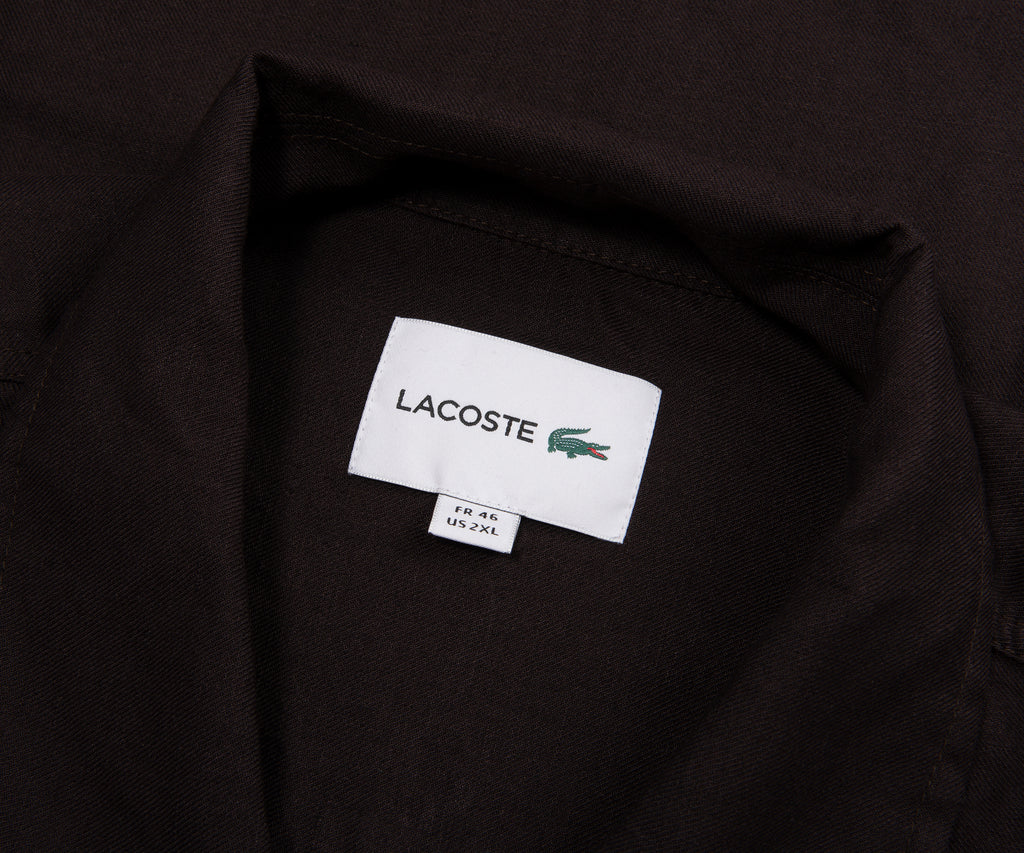 Close-up of a Lacoste label on a black shirt
