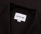 Close-up of a Lacoste label on a black shirt